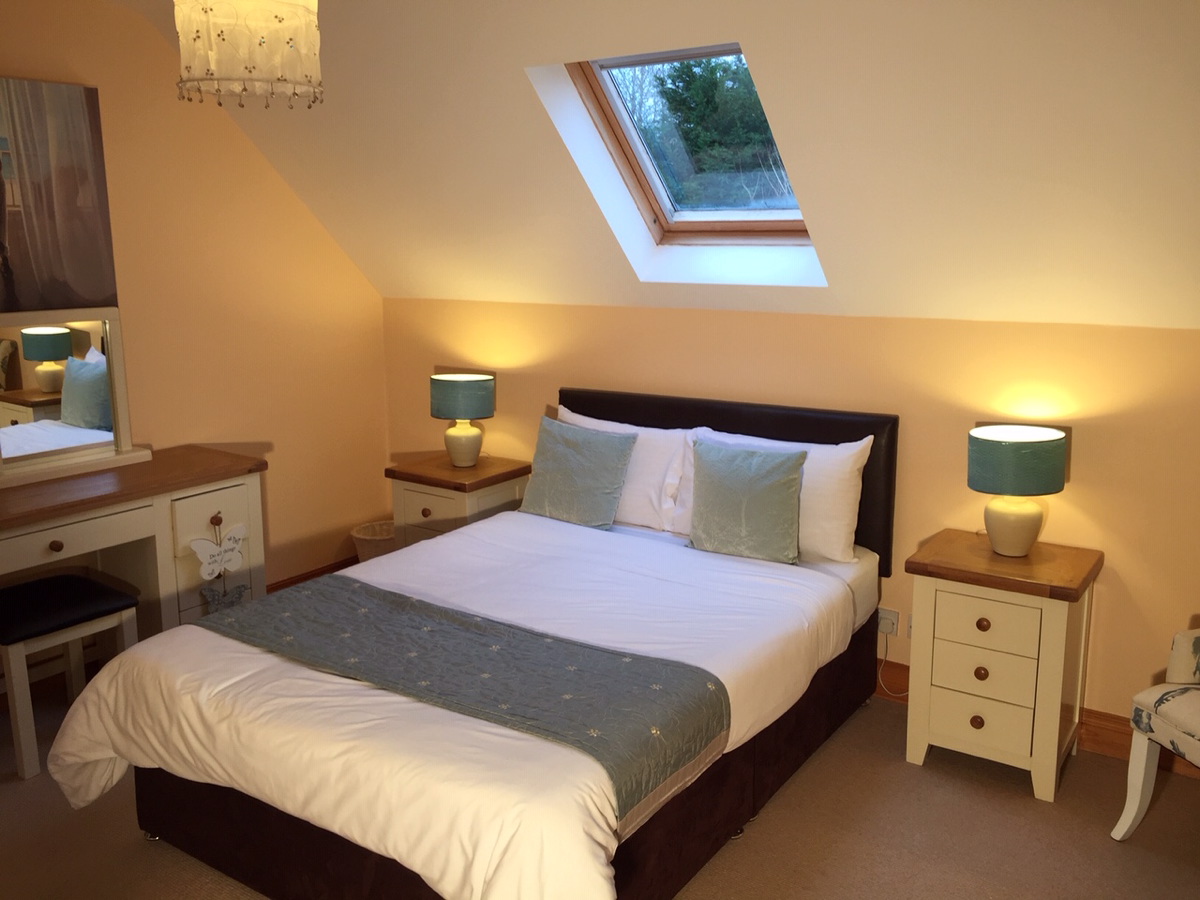 Double bedroom with a skylight and bedside lamps